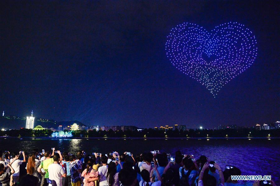 People view drones performance at the Orange Isle scenic area in Changsha, central China\'s Hunan Province, Aug. 16, 2018. Groups of drones performed a light show here to greet the Qixi festival, or Chinese Valentine\'s Day, which falls on Aug. 17 this year. (Xinhua/Zhang Xiaoyu)