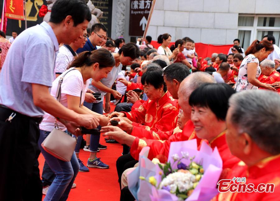 Young people offer tea to elderly couples during a golden wedding anniversary celebration on Laojun Mountain in Luanchuan County, Central China’s Henan Province, Aug. 16, 2018, in the run up to Qixi Festival, known as China’s Valentine\'s Day. Falling on the seventh day of the seventh lunar month on the Chinese calendar - Aug. 17, this year - the festival celebrates the annual meeting of the cowherd and weaver girl in Chinese mythology. (Photo: China News Service/Wang Zhongju)