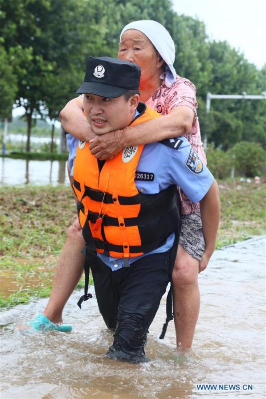 A rescuer transfers an old woman in flood in Huaibei City, east China\'s Anhui Province, Aug. 19, 2018. Typhoon Rumbia has brought heavy rain to Huaibei and some places in Huaibei were inundated by flood. (Xinhua/Wan Shanchao)