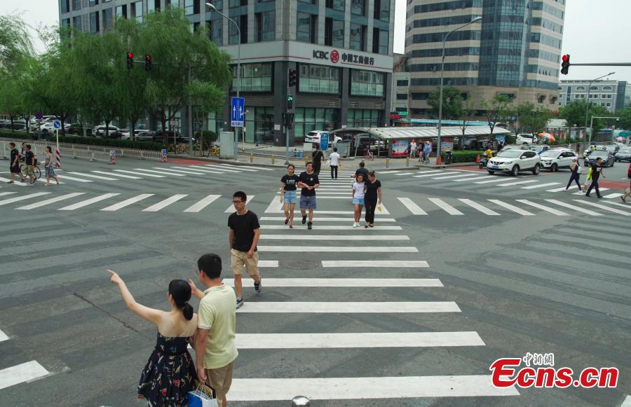 A new pedestrian crossing layout at the intersection of Lugu West Road and Zhengda Road in Shijiangshan District, Beijing, Aug. 19, 2018. When given the green light, pedestrians can choose to cross the intersection diagonally to get to the opposite corner in addition to simply crossing from one side of the road to the other. It is believed to be the first intersection with such an option for pedestrians in Beijing. (Photo: China News Service/Jia Tianyong)