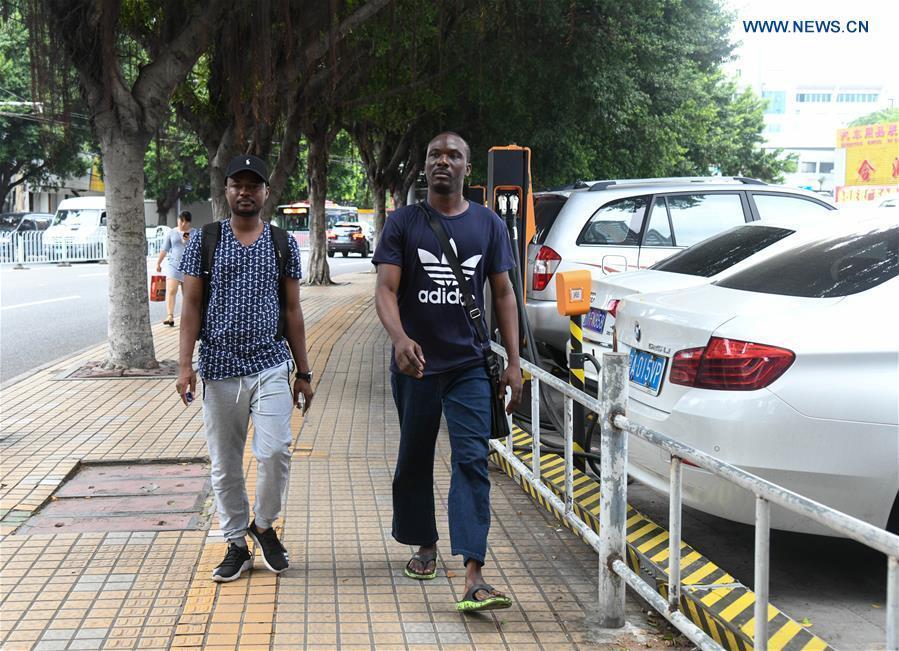 Mansur Barhama Abulfathi (L) from Nigeria walks on a road with his friend in Guangzhou, south China\'s Guangdong Province, Aug. 14, 2018. This 24-year-old young man has a Chinese name Quan Xiaobao. Quan Xiaobao has lived in Guangzhou for over one year, and his fluency in Chinese allows him to work part-time as a translator and business consultant. Located near Hong Kong and Macao special administrative regions, Guangzhou attracts many Africans to work or study here. Guangzhou government has stepped up the work to provide all-round service for foreigners to help them adapt to the local environment. (Xinhua/Deng Hua)