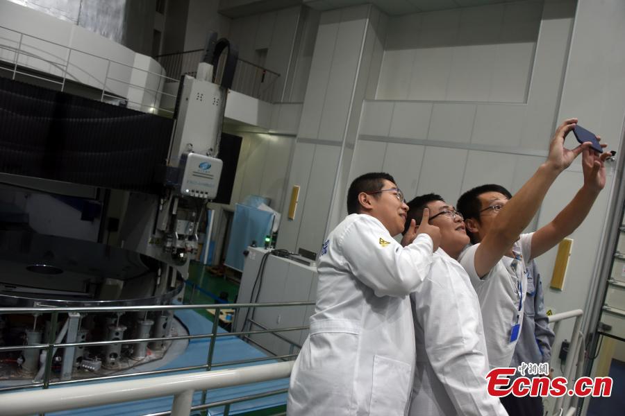 Researchers with the CAS Changchun Institute of Optics, Fine Mechanics and Physics pose for a photo after a silicon carbide (SiC) single mirror blank with a diameter of 4.03 m was given the OK for project use in Changchun City, Northeast China’s Jilin Province, Aug. 21, 2018. The mirror blank is a vital component for creating a large-scale telescope, and the bigger it is the more capable it is of detecting visible light bands. (Photo: China News Service/Sun Zifa)
