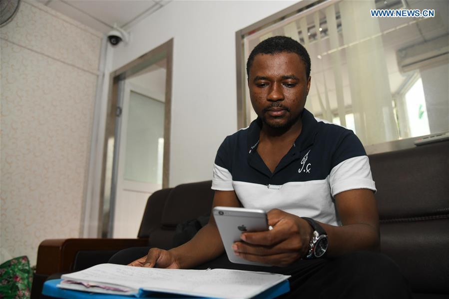 Mansur Barhama Abulfathi from Nigeria checks up accounts at an office room in Guangzhou, south China\'s Guangdong Province, Aug. 15, 2018. This 24-year-old young man has a Chinese name Quan Xiaobao. Quan Xiaobao has lived in Guangzhou for over one year, and his fluency in Chinese allows him to work part-time as a translator and business consultant. Located near Hong Kong and Macao special administrative regions, Guangzhou attracts many Africans to work or study here. Guangzhou government has stepped up the work to provide all-round service for foreigners to help them adapt to the local environment. (Xinhua/Deng Hua)