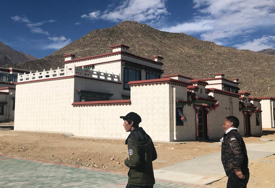 Siyo Tsenga and his son Tagyal head to their new house in a settlement in Doilungdechen district in Lhasa, Tibet autonomous region. [Photo by PALDEN NYIMA/CHINA DAILY]