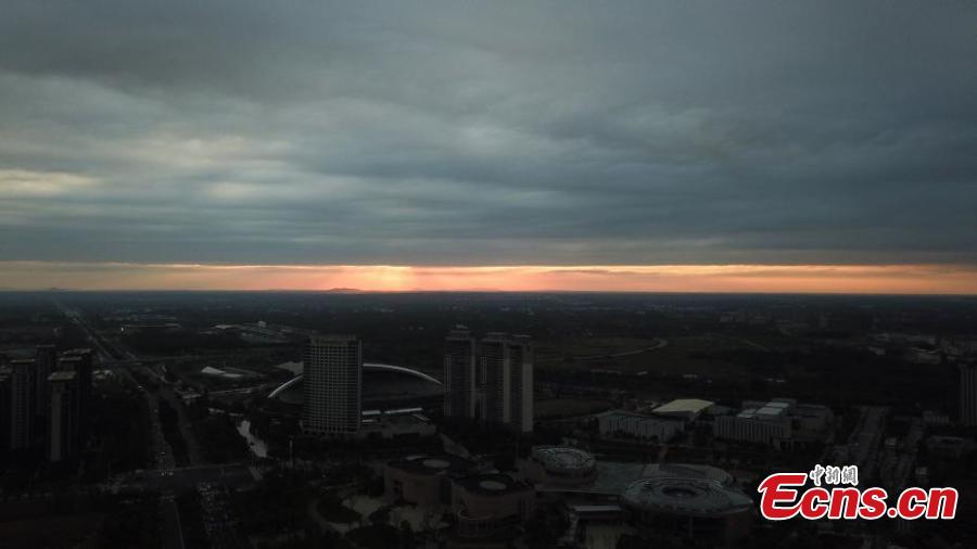 Dark clouds create a distinct line in the sky as the sun sets over Yangzhou City, Jiangsu Province, Aug. 21, 2018. The sunset created an intense orange glow that contrasted with the dark clouds, creating a spectacular natural wonder. (Photo: China News Service/Meng Delong)