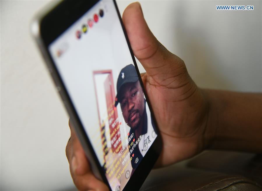 Mansur Barhama Abulfathi from Nigeria communicates with fans on-line at his apartment in Guangzhou, south China\'s Guangdong Province, Aug. 13, 2018. This 24-year-old young man has a Chinese name Quan Xiaobao. Quan Xiaobao has lived in Guangzhou for over one year, and his fluency in Chinese allows him to work part-time as a translator and business consultant. Located near Hong Kong and Macao special administrative regions, Guangzhou attracts many Africans to work or study here. Guangzhou government has stepped up the work to provide all-round service for foreigners to help them adapt to the local environment. (Xinhua/Deng Hua)