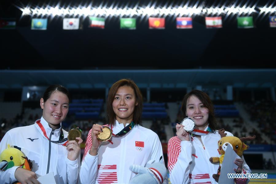 Liu Xiang (C) of China celebrates during the awarding ceremony after women\'s 50m backstroke final of swimming at the 18th Asian Games in Jakarta, Indonesia, Aug. 21, 2018. Liu won the gold with 26.98 seconds and set a new world record. (Xinhua/Li Xiang)