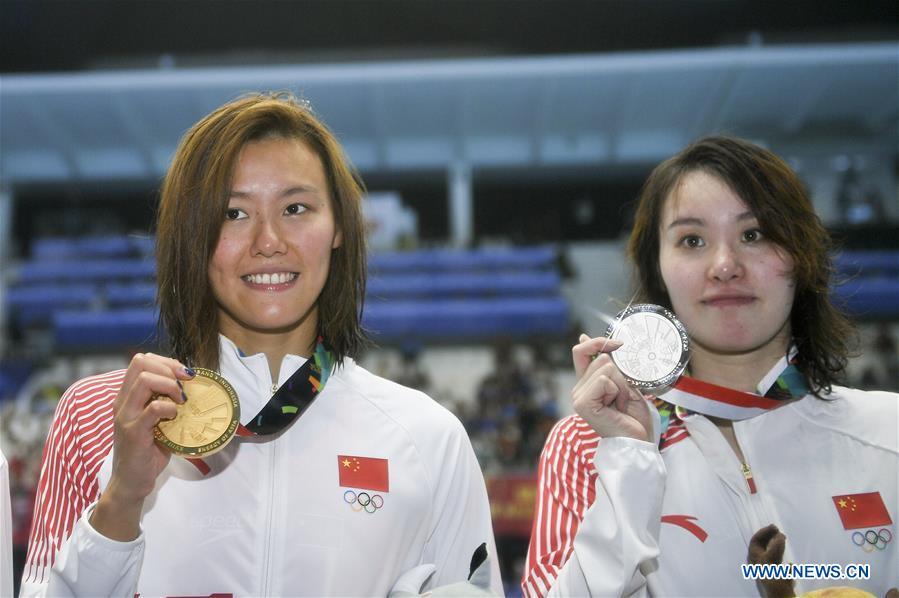 Liu Xiang (L) of China celebrates during the awarding ceremony after women\'s 50m backstroke final of swimming at the 18th Asian Games in Jakarta, Indonesia, Aug. 21, 2018. Liu won the gold with 26.98 seconds and set a new world record. (Xinhua/Li Xiang)