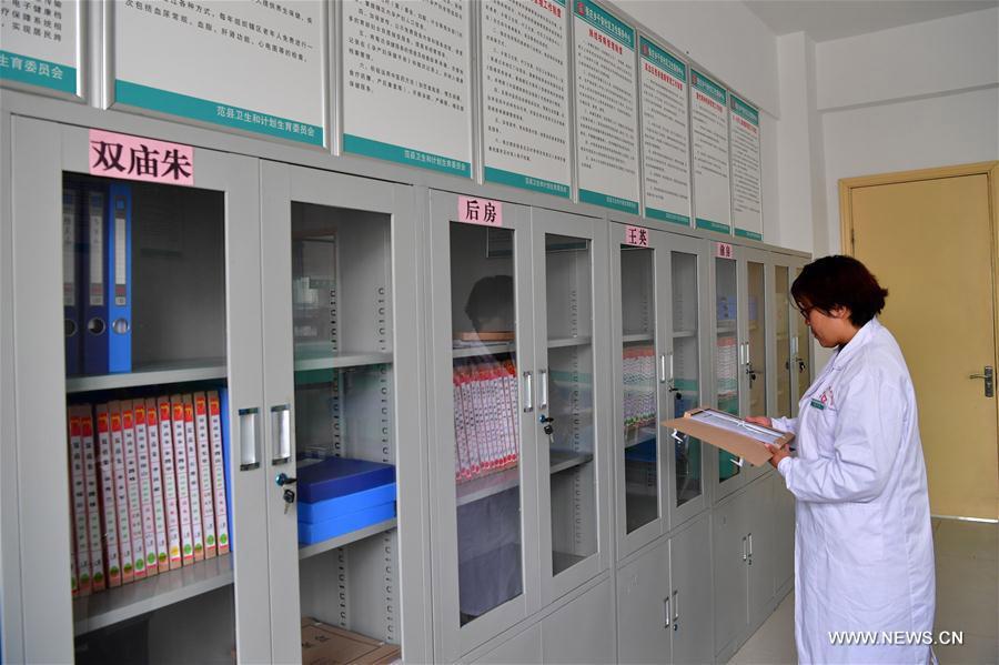 A doctor checks residents\' health files at a resettlement community at Zhangzhuang township of Fanxian county, Central China\'s Henan Province, Nov. 1, 2017. (Photo/Xinhua)