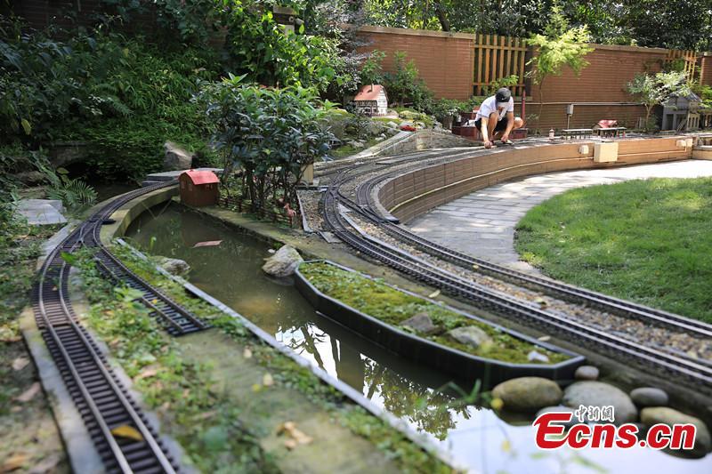 Zhang Yong’an, 63, and his family members have spent five years and more than one million yuan ($145,000) building a ‘train kingdom\' in their 330-sqm home garden in Wenjiang District, Chengdu City, Southwest China’s Sichuan Province. A great fan of train models from an early age, Zhang has tried his best to present every part of a real railway station with vivid models, including train lights, tunnels, passengers, platforms, freight trains and passenger trains. When it rains, Zhang drives all the trains indoors by remote control. (Photo: China News Service/Wu Pinghua)