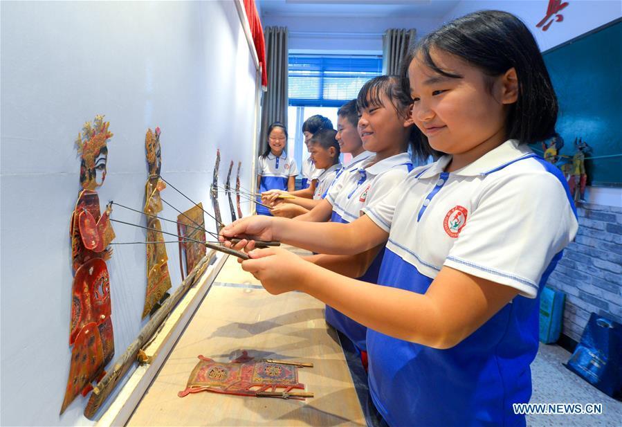 Primary school students experience the performing of traditional shadow puppet show in Feixiang District of Handan, north China\'s Hebei Province, Aug. 25, 2017. (Xinhua/Wang Xiao)