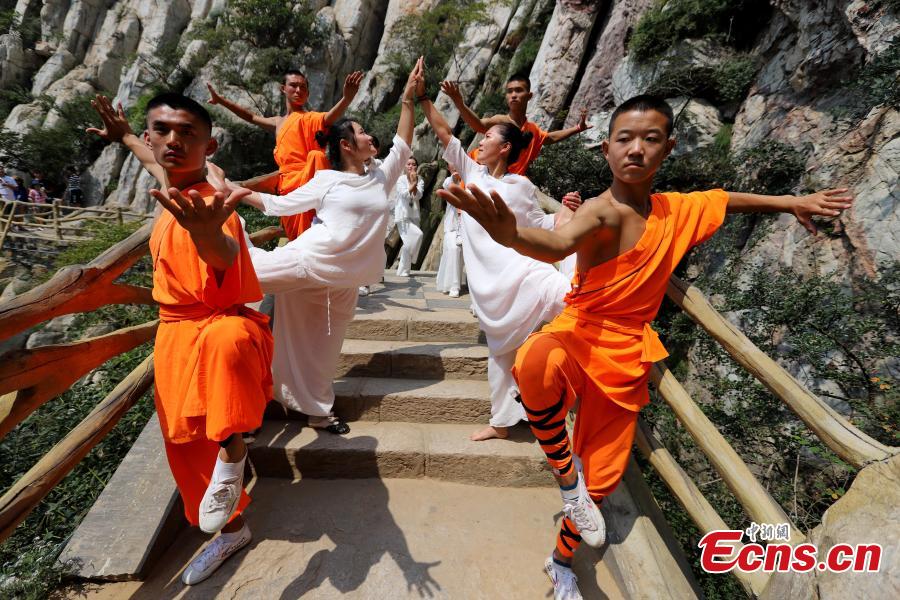 Yoga and kung fu enthusiasts perform in a cultural festival on Mount Song, home to the Shaolin Temple, in Dengfeng, Central China’s Henan Province, Aug. 25, 2018. (Photo: China News Service/Wang Zhongju)
