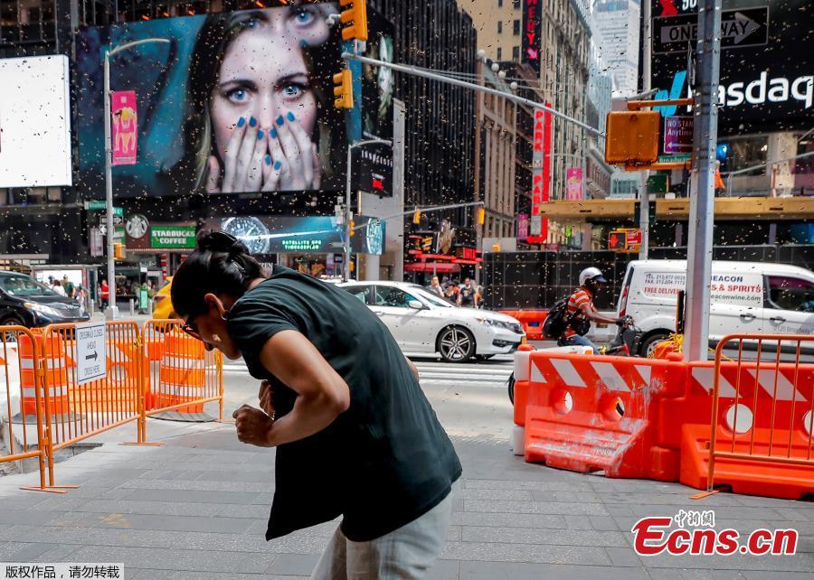 A woman reacts to a swarm of bees in Times Square in New York City, U.S., Aug. 28, 2018. The New York Police Department\'s bee keepers unit responded to the scene and safely removed the bees without incident. (Photo/Agencies)