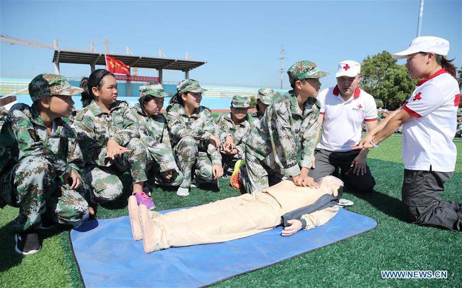 Newly-enrolled middle school students learn to do first aid during military training practice at Xinshi Middle School in Xinshi Town of Huzhou City, east China\'s Zhejiang Province, Aug. 29, 2018. Schools in China prepared many activities for students to greet the new semester after summer vacation. (Xinhua/Xie Shangguo)