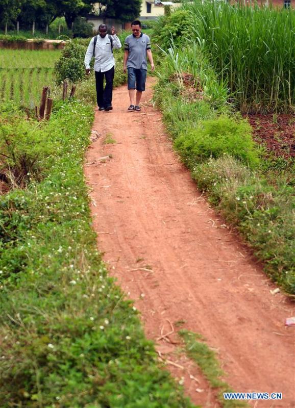 Diarra (L) walks on a road in Dazhuang Village under Kaiyuan City of Hani-Yi Autonomous Prefecture of Honghe, southwest China\'s Yunnan Province, June 6, 2017. (Xinhua/Wang Changshan)