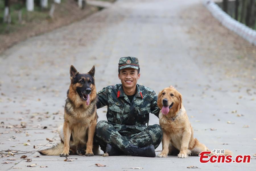Armed police officer Han Menglin spends his last moments with police dogs he worked with at a training base in Guizhou Province, Aug. 31, 2018. (Photo: China News Service/Qu Honglun)