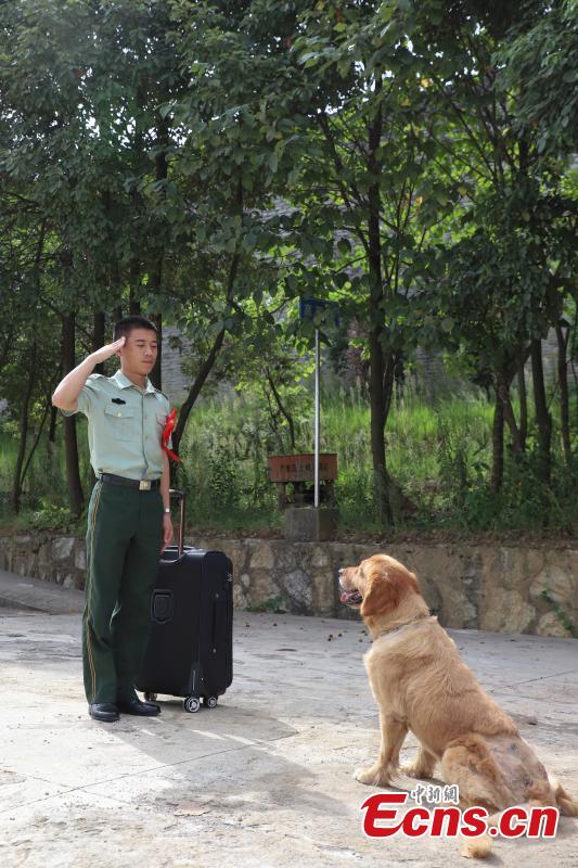 Armed police officer Han Menglin spends his last moments with a police dog at a training base before ending his military service in Guizhou Province, Aug. 31, 2018. (Photo: China News Service/Qu Honglun)
