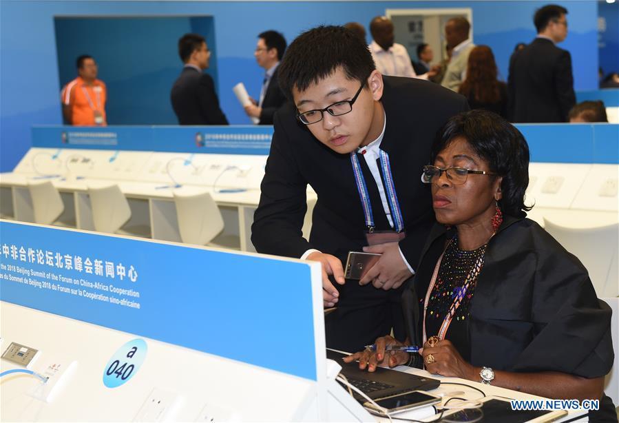 Liu Juncen (L, front), a volunteer from the University of International Business and Economics, provides service to a journalist from Cameroon at the media center for the Beijing Summit of the Forum on China-Africa Cooperation (FOCAC) in Beijing, capital of China, Sept. 3, 2018. The FOCAC Beijing Summit involves some 2,500 volunteers, most of whom are students from 32 higher education institutions. The volunteers are mainly responsible for tasks in venue services, guest reception, registration, media services and transportation. (Xinhua/Luo Xiaoguang)
