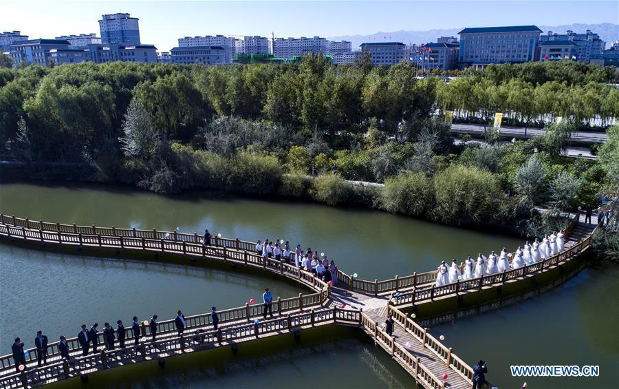 Aerial photo taken on Sept. 7, 2018 shows the group wedding ceremony at a wetland park along the Heihe River in Gaotai County of Zhangye City, northwest China\'s Gansu Province. (Xinhua/Tao Ming)