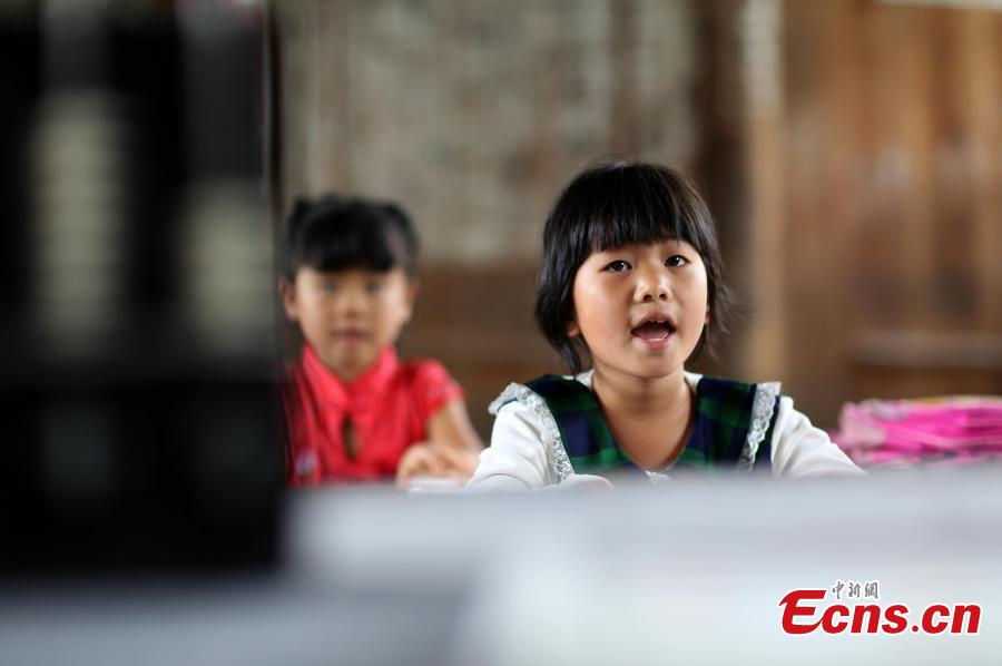 First grader Wang Fangying studies at a school in Danggan Village, Paitiao Town, Guizhou Province, Sept. 7, 2018. Yang, 40, is the only teacher in the school that has one first grader and seven pre-school children from nearby villages. If not for the school, children would have to travel to a town more than 20 kilometers away to study. (Photo: China News Service/Huang Xiaohai)