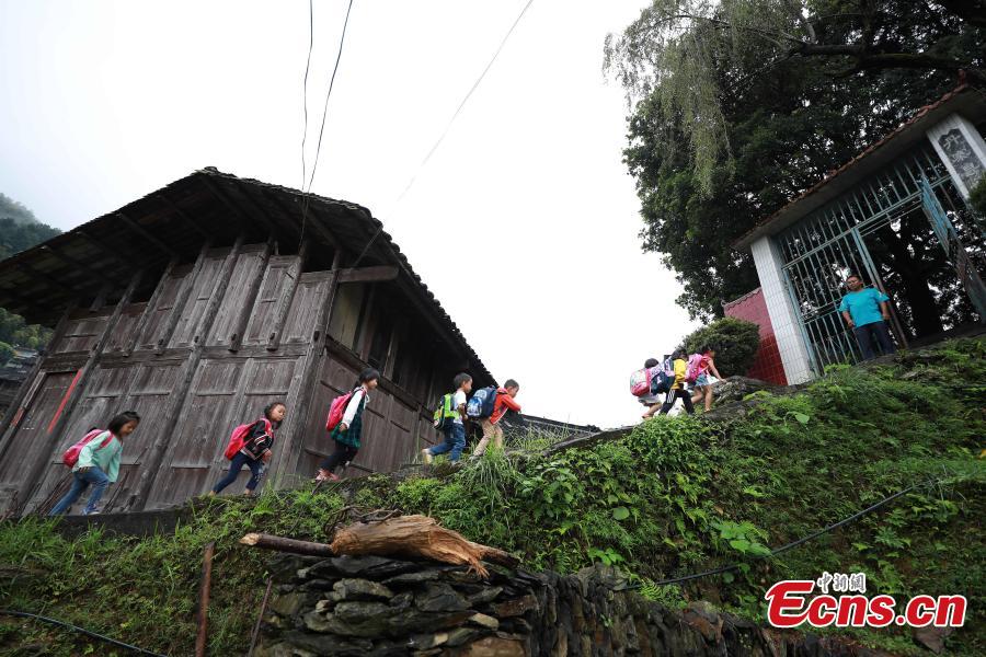 Yang Changjun greets children at a school in Danggan Village, Paitiao Town, Guizhou Province, Sept. 7, 2018. Yang, 40, is the only teacher in the school that has one first grader and seven pre-school children from nearby villages. If not for the school, children would have to travel to a town more than 20 kilometers away to study. (Photo: China News Service/Huang Xiaohai)