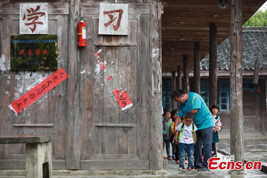 Teacher Yang Changjun sees off students as they leave school in Danggan Village, Paitiao Town, Guizhou Province, Sept. 7, 2018. Yang, 40, is the only teacher in the school that has one first grader and seven pre-school children from nearby villages. If not for the school, children would have to travel to a town more than 20 kilometers away to study. (Photo: China News Service/Huang Xiaohai)