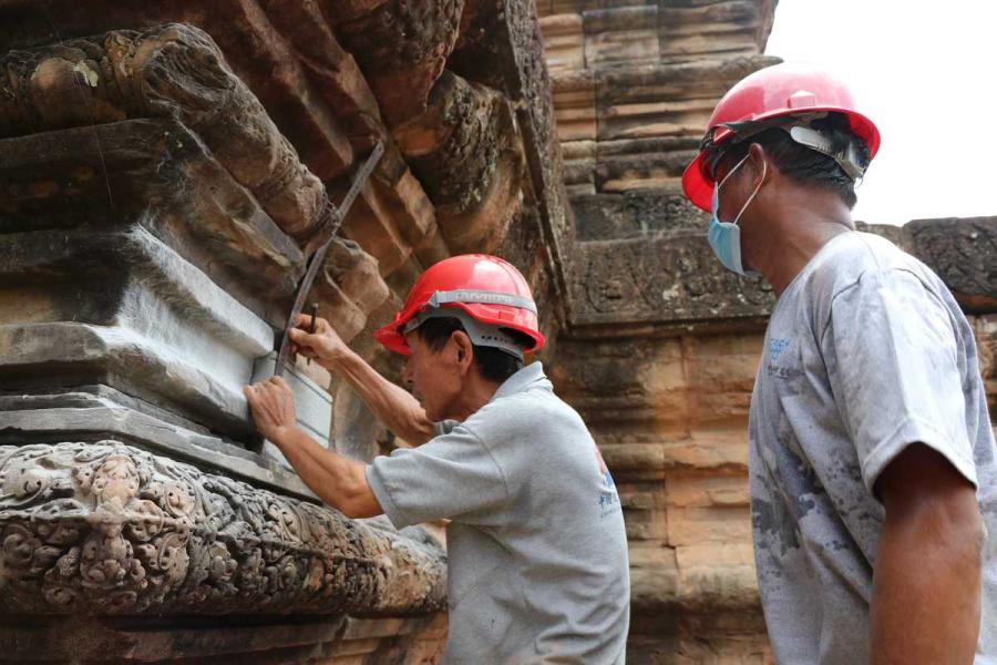 Chinese specialists help renovate Ta Keo Temple at the Angkor complex in Cambodia in July. (Photo/Xinhua)
Coordination between different countries key to success
August is probably not the best time for tourists to travel to Angkor Archaeological Park in northern Cambodia, as the rainy season brings particularly muggy conditions.
But for Yuan Mengxi, an assistant researcher at the Chinese Academy of Cultural Heritage, her trip last month was perhaps one of her most exciting, although she had been there more than 10 times.
Restoration of Ta Keo, a temple at the site built in the 10th and 11th centuries, has been completed.
\