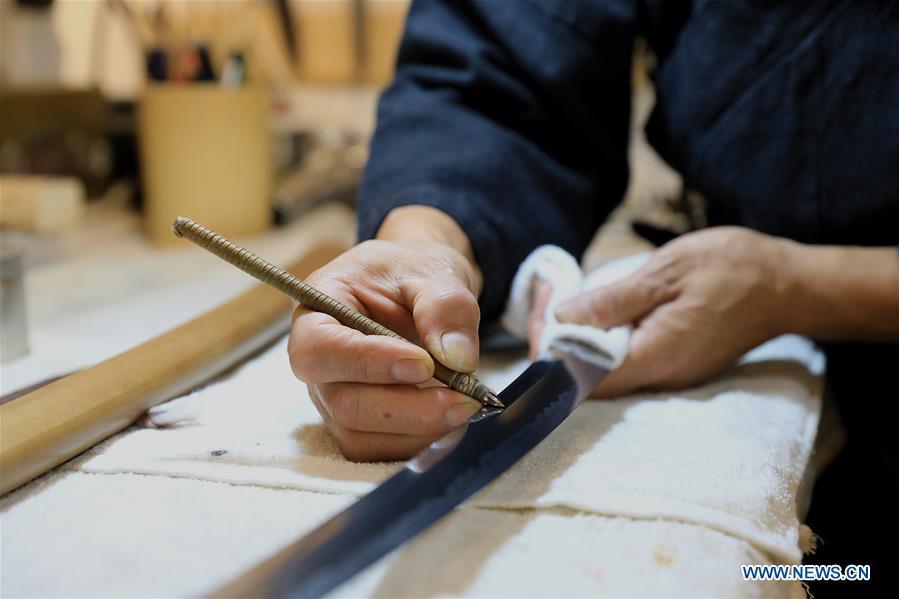 Yan Min restores an ancient weapon in Shijiazhuang, north China\'s Hebei Province, Sept. 11, 2018. Yan Min, dedicated to ancient weapon restoration for more than 30 years, has hitherto repaired over 500 pieces of ancient weapons with his son Yan Peng. Influenced by his father, Yan Peng quit his job and embarked on restoring ancient weapons in the year of 2015. The sophisticated craftsmanship of ancient weapon restoration embodies working procedures of polishing, burnishing, grinding etc. \