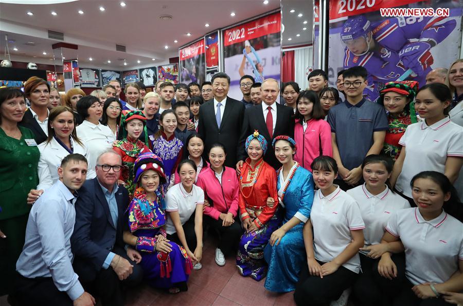 Chinese President Xi Jinping and Russian President Vladimir Putin pose for photos with youths from China and Russia and faculty representatives as they visit the All-Russian Children\'s Center \