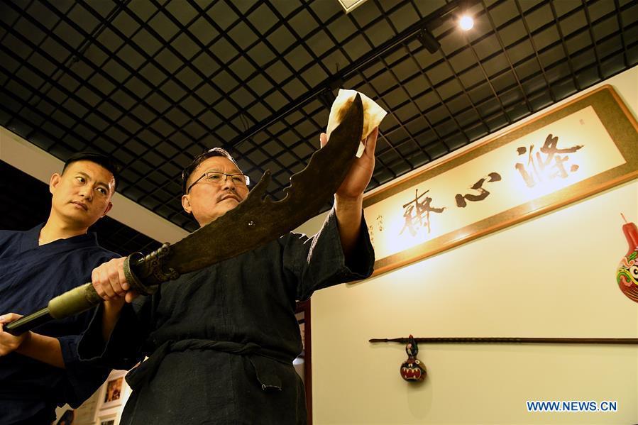 an Min (R) wipes a repaired ancient weapon clean with his son in Shijiazhuang, north China\'s Hebei Province, Sept. 11, 2018. Yan Min, dedicated to ancient weapon restoration for more than 30 years, has hitherto repaired over 500 pieces of ancient weapons with his son Yan Peng. Influenced by his father, Yan Peng quit his job and embarked on restoring ancient weapons in the year of 2015. The sophisticated craftsmanship of ancient weapon restoration embodies working procedures of polishing, burnishing, grinding etc. \