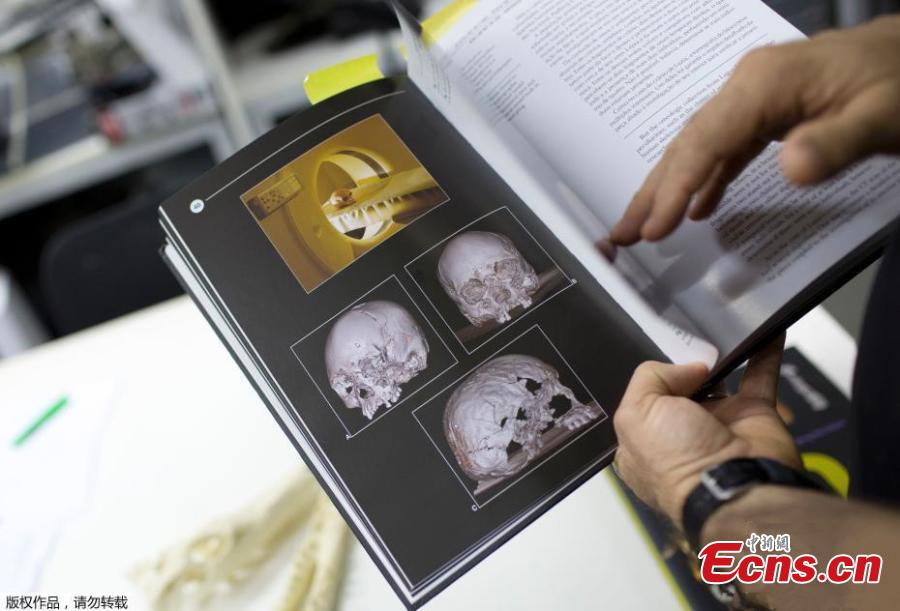 Jorge Lopes, researcher at the Pontifical Catholic University, shows a book with pictures of originals and scanned replicas of some of the artifacts that were inside the Museo Nacional, in Rio de Janeiro, Brazil, Sept. 5, 2018. About 300 pieces of the Brazil\'s National Museum that were scanned and some printed in 3D could help to rebuild part of the heritage lost in the fire this weekend. Since 2000, researchers at the PUC worked together with the museum, scanning and printing some of the most important objects of the institution. (Photo/Agencies)