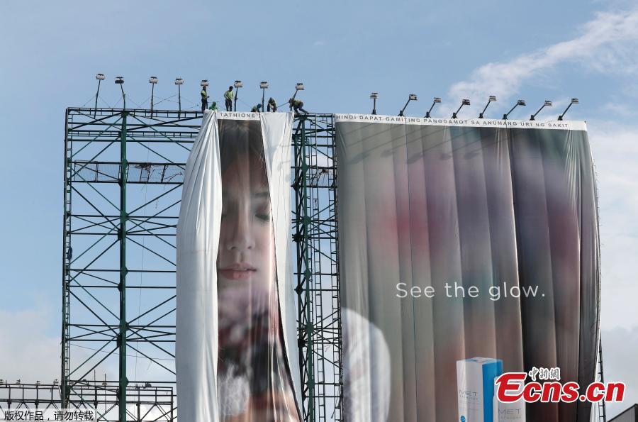 Workers roll advertising billboards along main road EDSA in preparation for the coming of Super Typhoon Mangkhut before it hits the main island of Luzon, in Quezon City, Metro Manila, Philippines, Sept. 12, 2018. (Photo/Agencies)