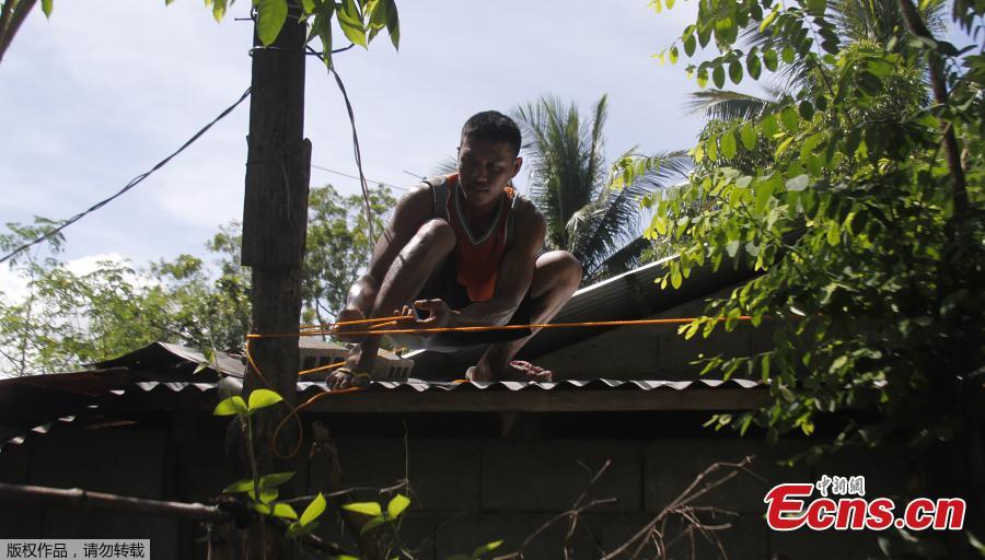 A resident secures the roof of his house in preparation for Super Typhoon Mangkut in Candon City, Ilocos Sur province, north of Manila on Sept. 13, 2018. The most powerful typhoon of the year roared toward the Philippines on Thursday, prompting thousands to evacuate ahead of its heavy rains and fierce winds that are set to strike at the weekend. (Photo/Agencies)