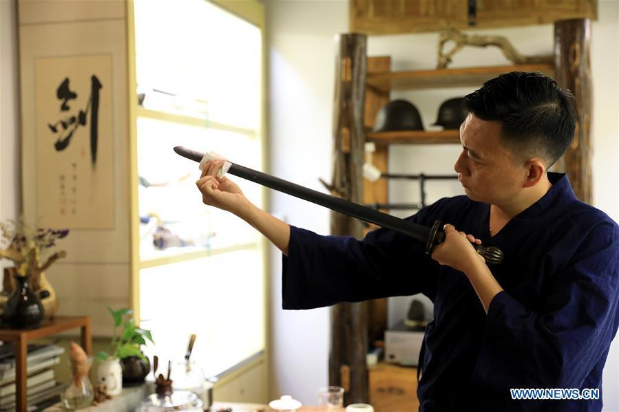 Yan Peng checks a repaired ancient weapon in Shijiazhuang, north China\'s Hebei Province, Sept. 11, 2018. Yan Min, dedicated to ancient weapon restoration for more than 30 years, has hitherto repaired over 500 pieces of ancient weapons with his son Yan Peng. Influenced by his father, Yan Peng quit his job and embarked on restoring ancient weapons in the year of 2015. The sophisticated craftsmanship of ancient weapon restoration embodies working procedures of polishing, burnishing, grinding etc. \