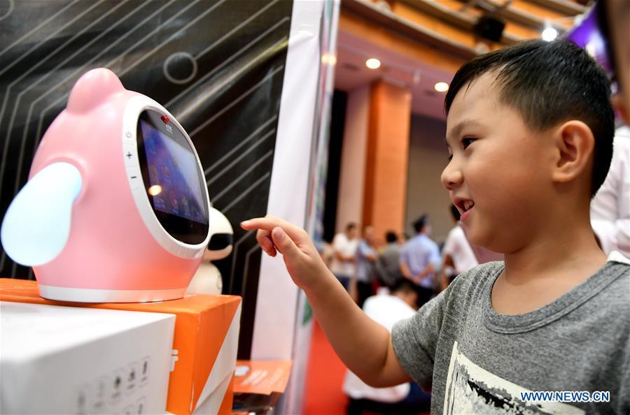 A boy interacts with a robot at the 15th China-ASEAN Expo in Nanning City, south China\'s Guangxi Zhuang Autonomous Region, Sept. 13, 2018. High-tech exhibits attracted many visitors at the expo. (Xinhua/Zhang Ailin)