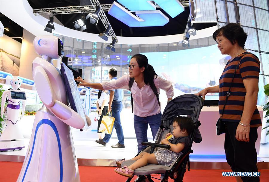 Visitors interact with a robot at the 15th China-ASEAN Expo in Nanning City, south China\'s Guangxi Zhuang Autonomous Region, Sept. 13, 2018. High-tech exhibits attracted many visitors at the expo. (Xinhua/Lu Bo\'an)