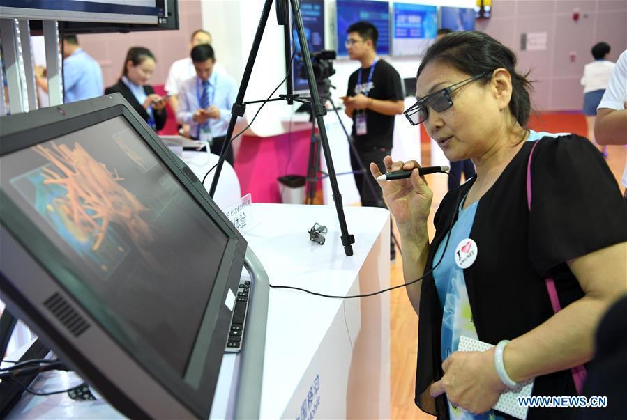 A visitor experiences a remote medical system at the 15th China-ASEAN Expo in Nanning City, south China\'s Guangxi Zhuang Autonomous Region, Sept. 13, 2018. High-tech exhibits attracted many visitors at the expo. (Xinhua/Zhou Hua)