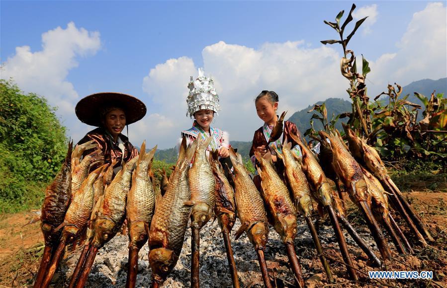 Villagers roast fishes during harvest celebrations held at a village of Miao ethnic group in Gandong Township in Miao Autonomous County of Rongshui, south China\'s Guangxi Zhuang Autonomous Region, Sept. 15, 2018. (Xinhua/Long Tao)
