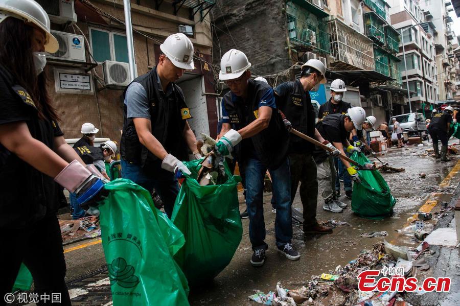 People clear a road in the aftermath of Super Typhoon Mangkhut in Macao, Sept. 17, 2018. (Photo/VCG)