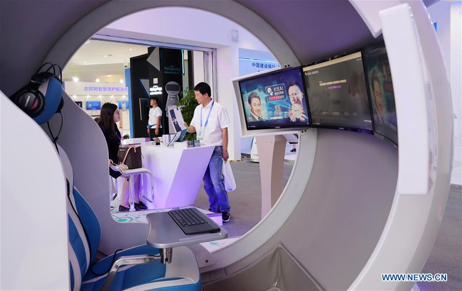 A visitor (R) consults at the stand of an educational organization during the World Artificial Intelligence Conference (WAIC) 2018 in Shanghai, east China, Sept. 17, 2018. The three-day conference has attracted experts, scholars and entrepreneurs from nearly 40 countries and regions. More than 200 leading companies in AI participated in the conference and the exhibition. (Xinhua/Fang Zhe)