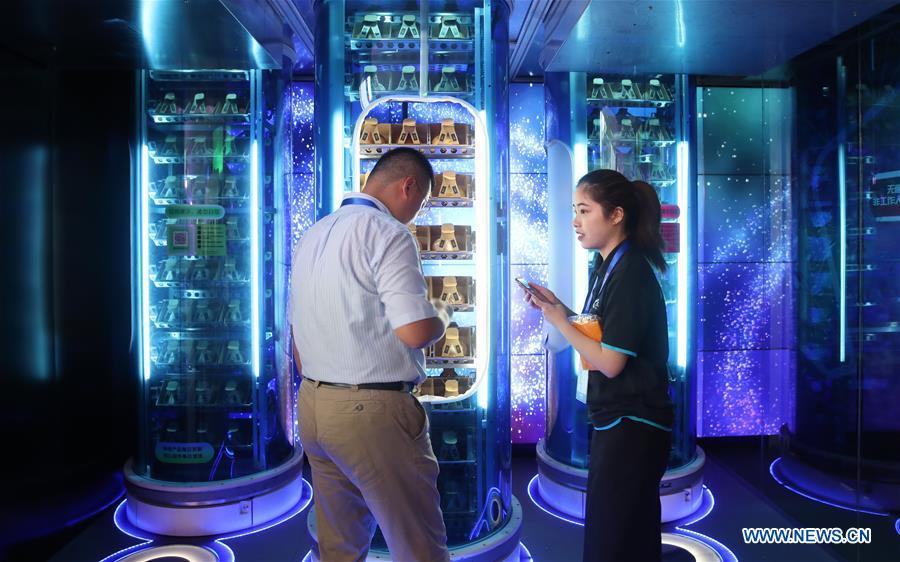 An exhibitor shows how to buy goods at an intelligent market during the World Artificial Intelligence Conference (WAIC) 2018 in Shanghai, east China, Sept. 17, 2018. The three-day conference has attracted experts, scholars and entrepreneurs from nearly 40 countries and regions. More than 200 leading companies in AI participated in the conference and the exhibition. (Xinhua/Ding Ting)