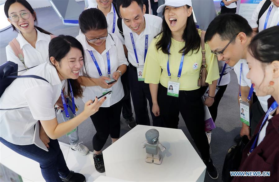 Visitors interact with a robot during the World Artificial Intelligence Conference (WAIC) 2018 in Shanghai, east China, Sept. 17, 2018. The three-day conference has attracted experts, scholars and entrepreneurs from nearly 40 countries and regions. More than 200 leading companies in AI participated in the conference and the exhibition. (Xinhua/Fang Zhe)