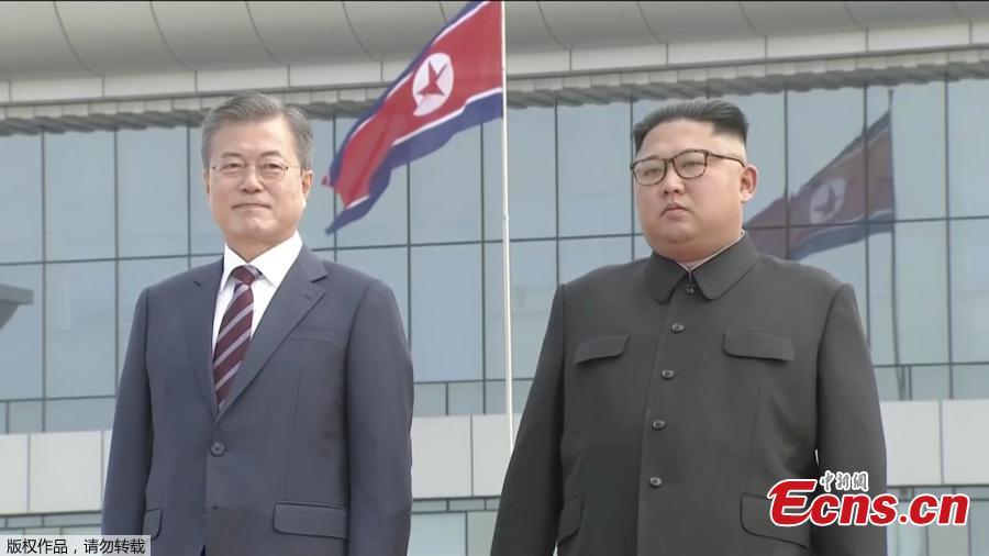 In this image made from video, South Korean President Moon Jae-in, left, poses with the Democratic People\'s Republic of Korea leader Kim Jong Un for a photo on the podium upon arrival in Pyongyang, Sept. 18, 2018. Moon landed in Pyongyang for his third summit this year with Kim. (Photo/Agencies)