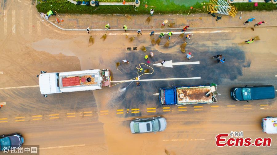 People clear a muddy road in the aftermath of Super Typhoon Mangkhut in Zhuhai City, South China’s Guangdong Province, Sept. 17, 2018. (Photo/VCG)