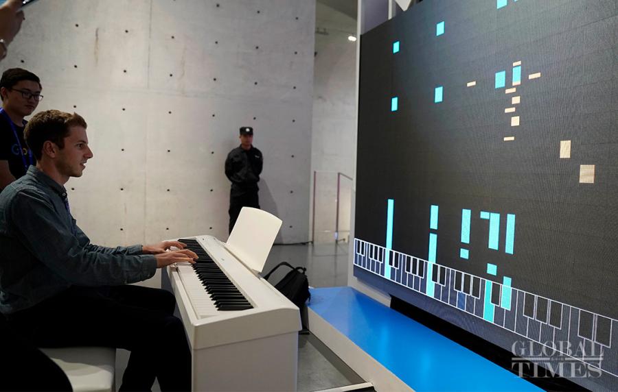 A visitor tries out an AI keyboard, which can produce music based on the prelude they just played. (Photo: Yang Hui/GT)