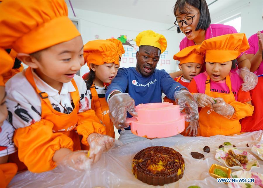 Children learn to make mooncakes at Shijixing kindergarten to greet the traditional Mid-Autumn Festival in Tangshan City, north China\'s Hebei Province, Sept. 21, 2018. The Mid-Autumn Festival falls on the 15th day of the eighth month of the Chinese lunar calendar, or Sept. 24 this year. (Xinhua/Yang Shiyao)