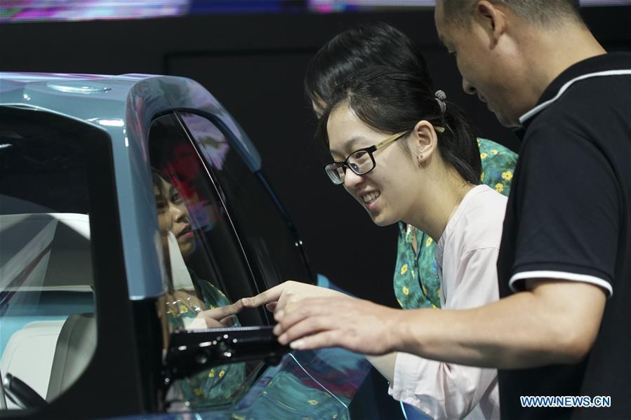 Visitors look at a new-energy vehicle exhibited at the Future of Transportation World Conference in Hangzhou, east China\'s Zhejiang Province, Sept. 20, 2018. (Xinhua)