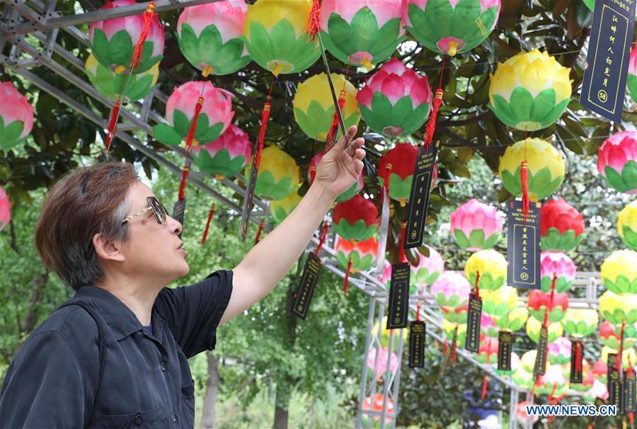 A visitor looks at a Chinese poems riddle card during a series of activities held to greet Mid-Autumn Festival in Shanghai, east China, Sept. 22, 2018. The Chinese traditional Mid-Autumn Festival falls on the 15th day of the eighth month on the Chinese lunar calendar, which is Sept. 24 this year. (Xinhua/Fang Zhe)