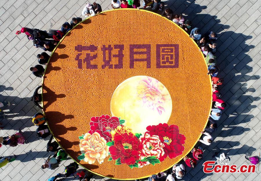 Staff members at Laojun Mountain, a scenic spot in Luoyang City, Central China\'s Henan Province, use 9,999 colorful mooncakes to spell out a beautiful pattern with Chinese characters of Hua Hao Yue Yuan (Blooming flowers and full moon) to celebrate the Mid-Autumn Festival, Sept. 23, 2018. (Photo: China News Service/Wang Zhongju)