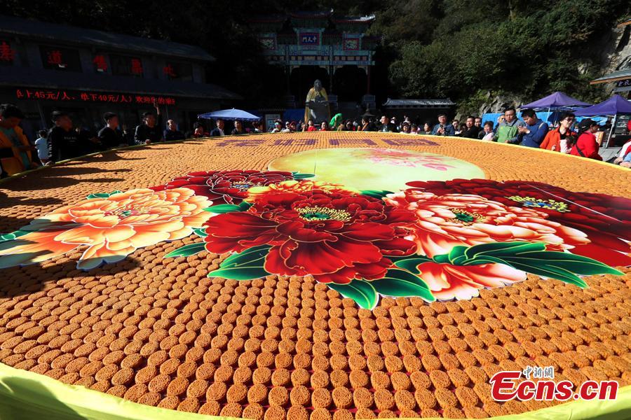 Staff members at Laojun Mountain, a scenic spot in Luoyang City, Central China\'s Henan Province, use 9,999 colorful mooncakes to spell out a beautiful pattern with Chinese characters of Hua Hao Yue Yuan (Blooming flowers and full moon) to celebrate the Mid-Autumn Festival, Sept. 23, 2018. (Photo: China News Service/Wang Zhongju)